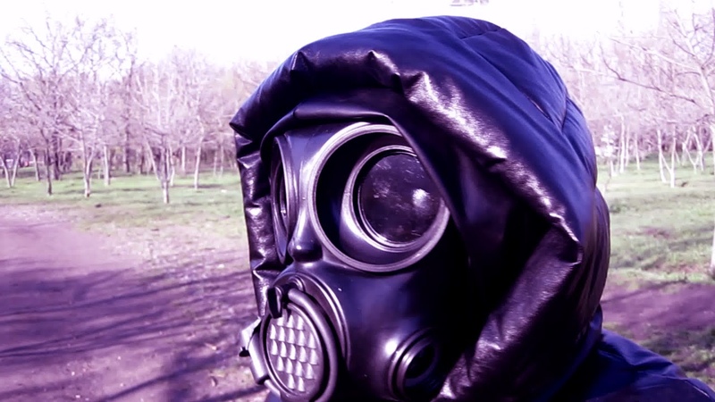 Girl in a black leather down jacket with a hood, in black leather leggings and Czech gas mask Om